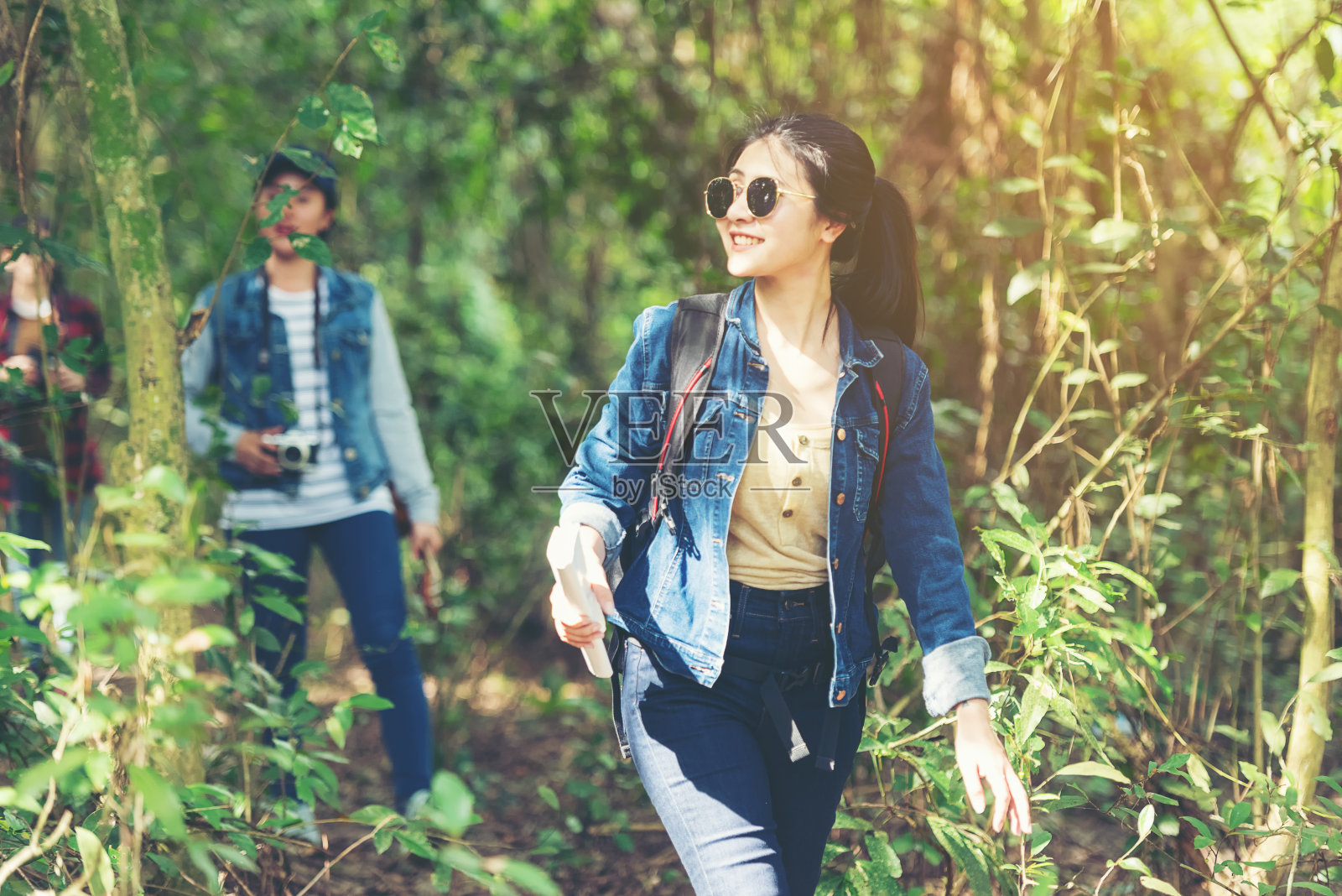 背包族在大自然中旅行，探索冒险。亚洲朋友和团队散步放松目的地休闲景观森林在夏季的一天。旅游和生活方式概念照片摄影图片