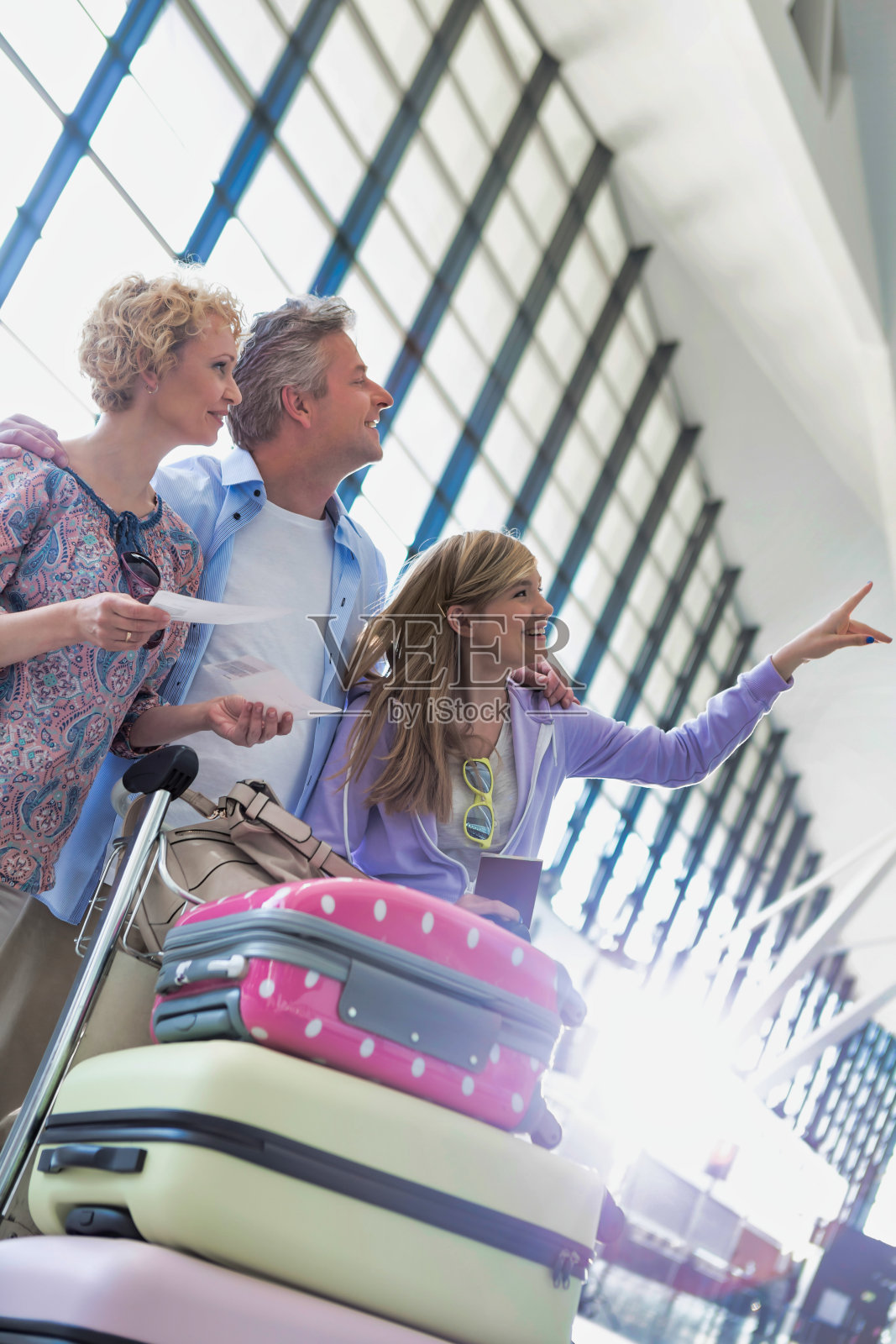 度假的家人在机场的监视器上查看他们的航班照片摄影图片