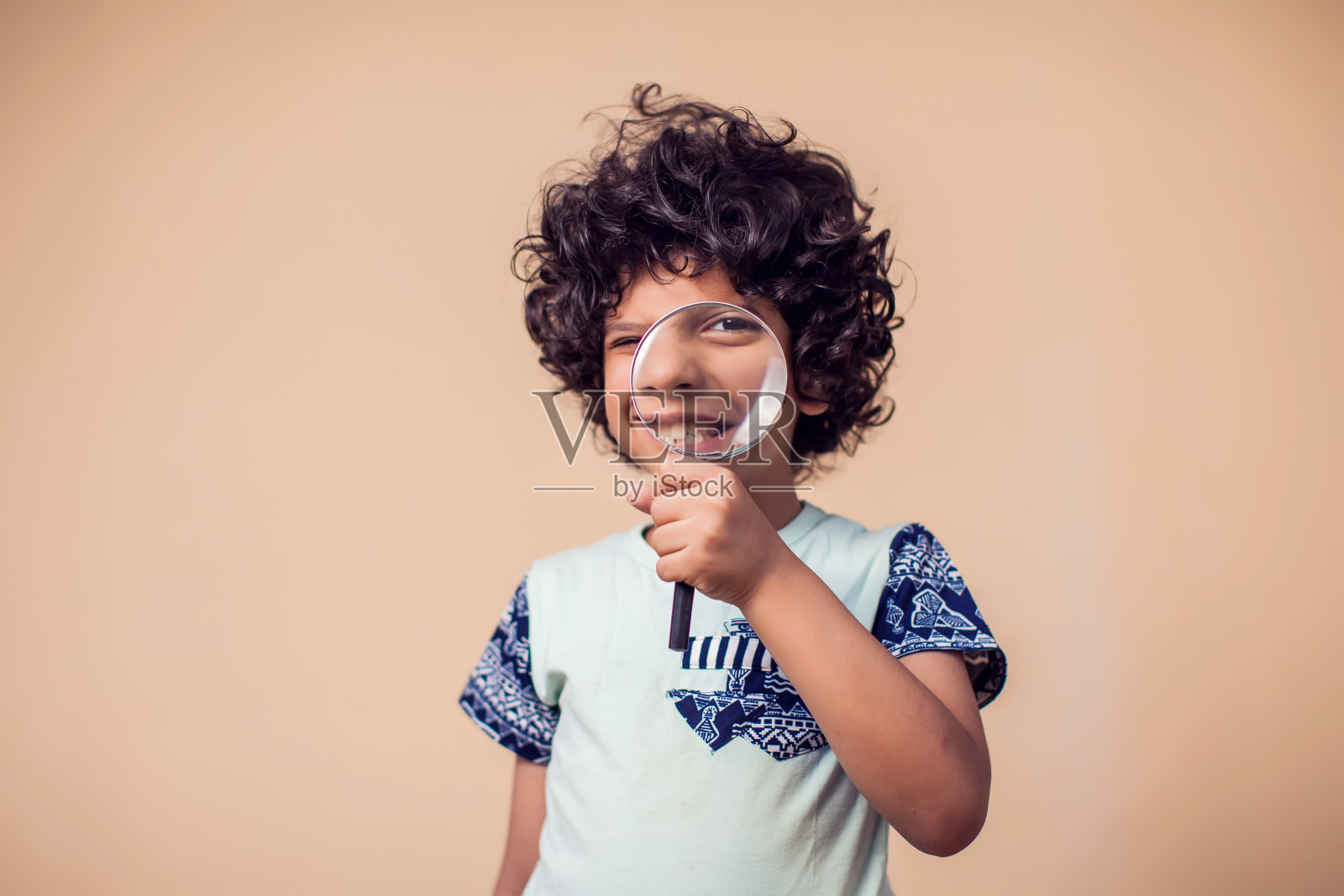 一个小男孩拿着放大镜的肖像。儿童与教育理念照片摄影图片