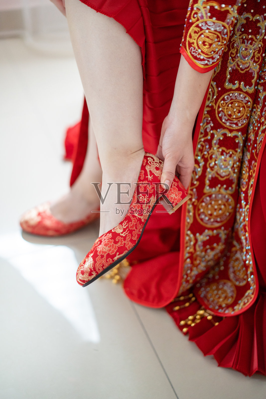 亚洲新娘身着传统服饰，穿着红色婚礼高跟鞋照片摄影图片