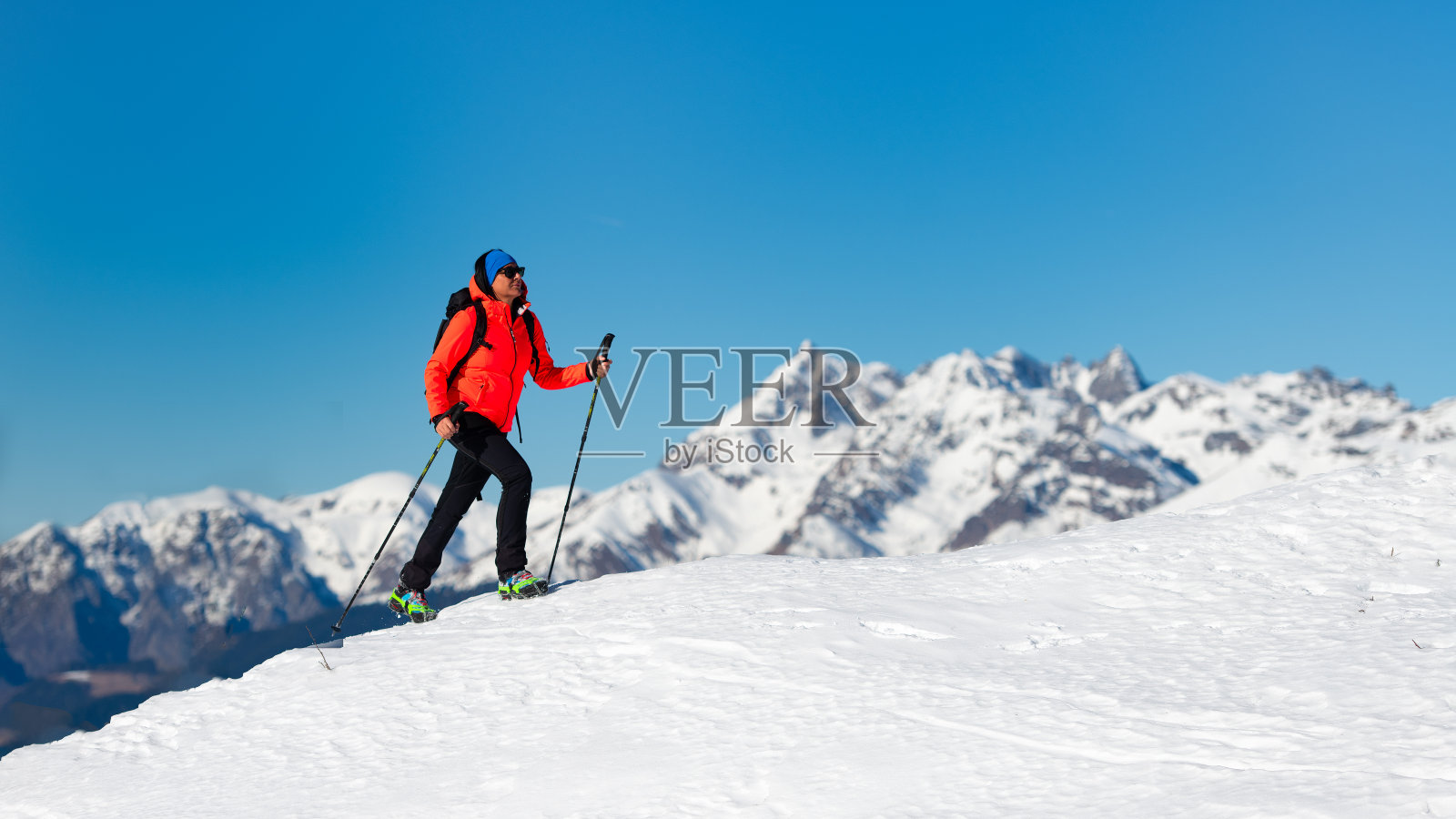 一个孤独的女人用冰爪在雪地上行走照片摄影图片