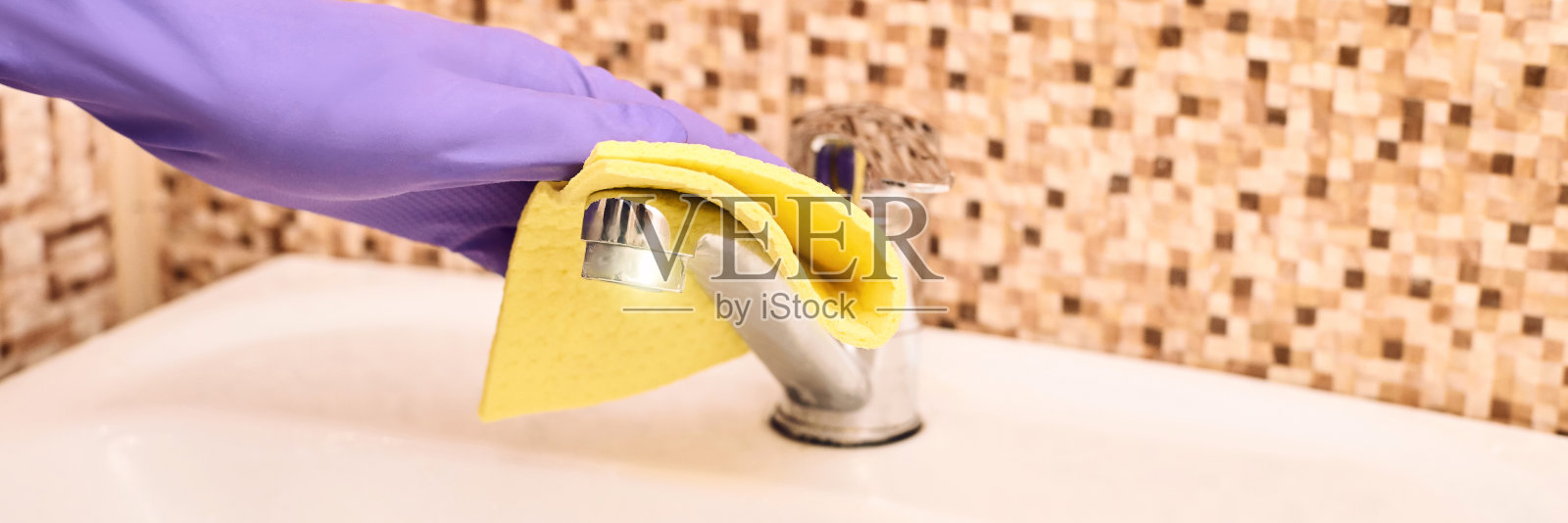 清洁工打扫浴室。紫色手套和黄色抹布照片摄影图片