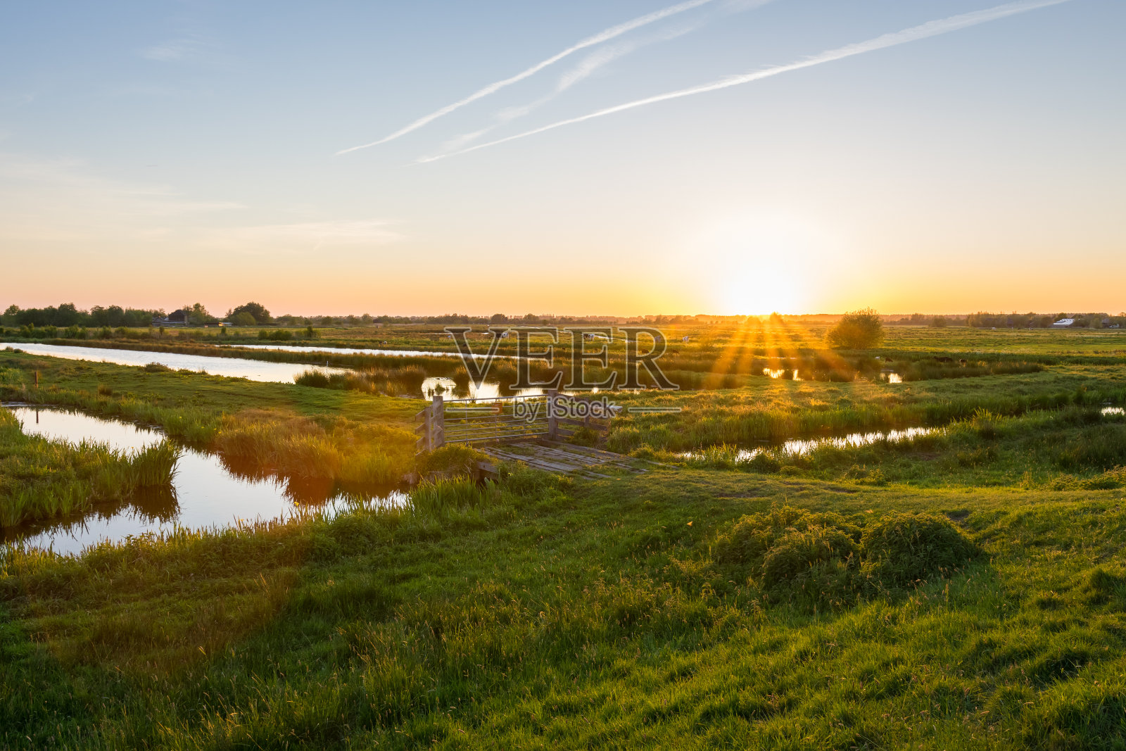 太阳落在开阔的荷兰圩田上照片摄影图片