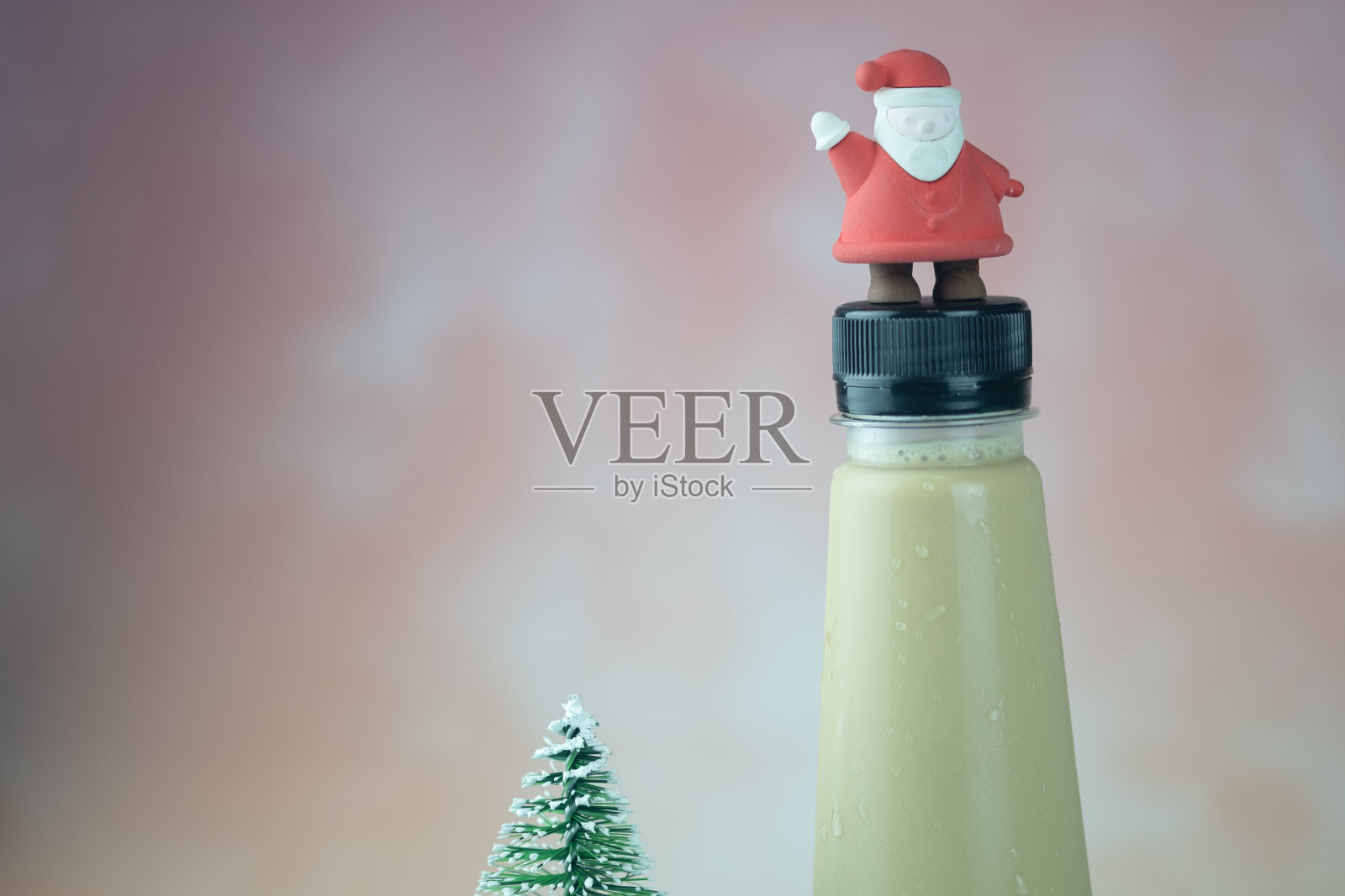 迷你圣诞老人放在咖啡塑料瓶上。圣诞节的概念照片摄影图片