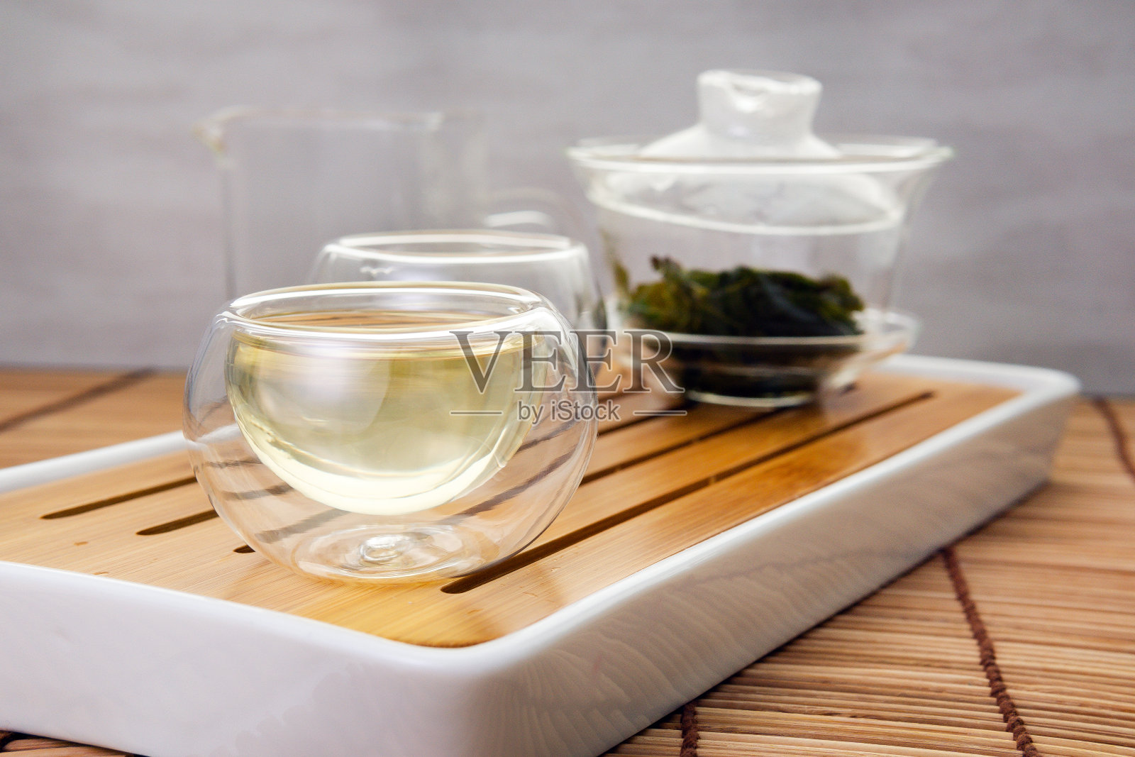 中国绿茶从玻璃茶壶到一个小杯子照片摄影图片