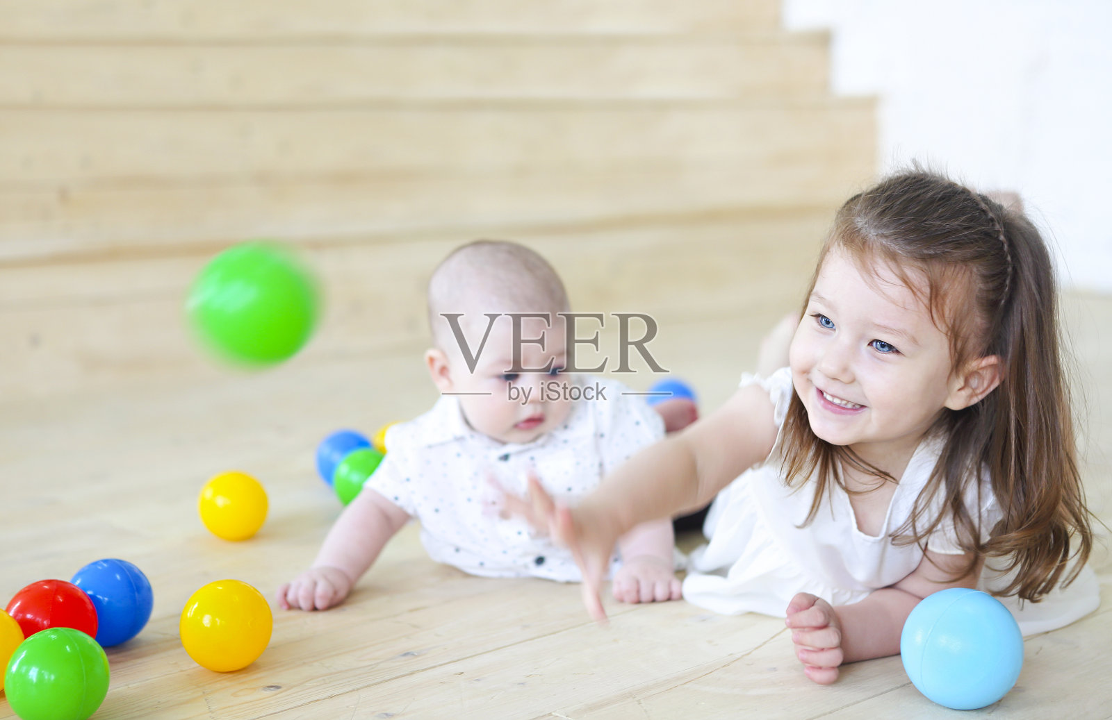 小男孩和他的妹妹在玩球。五颜六色的儿童玩具。游戏室里的孩子们照片摄影图片