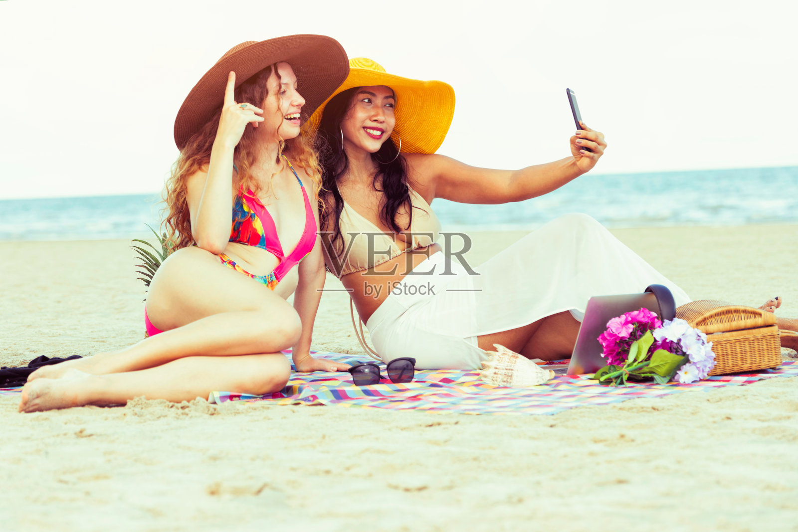 夏天在沙滩上拍照的快乐女人。照片摄影图片