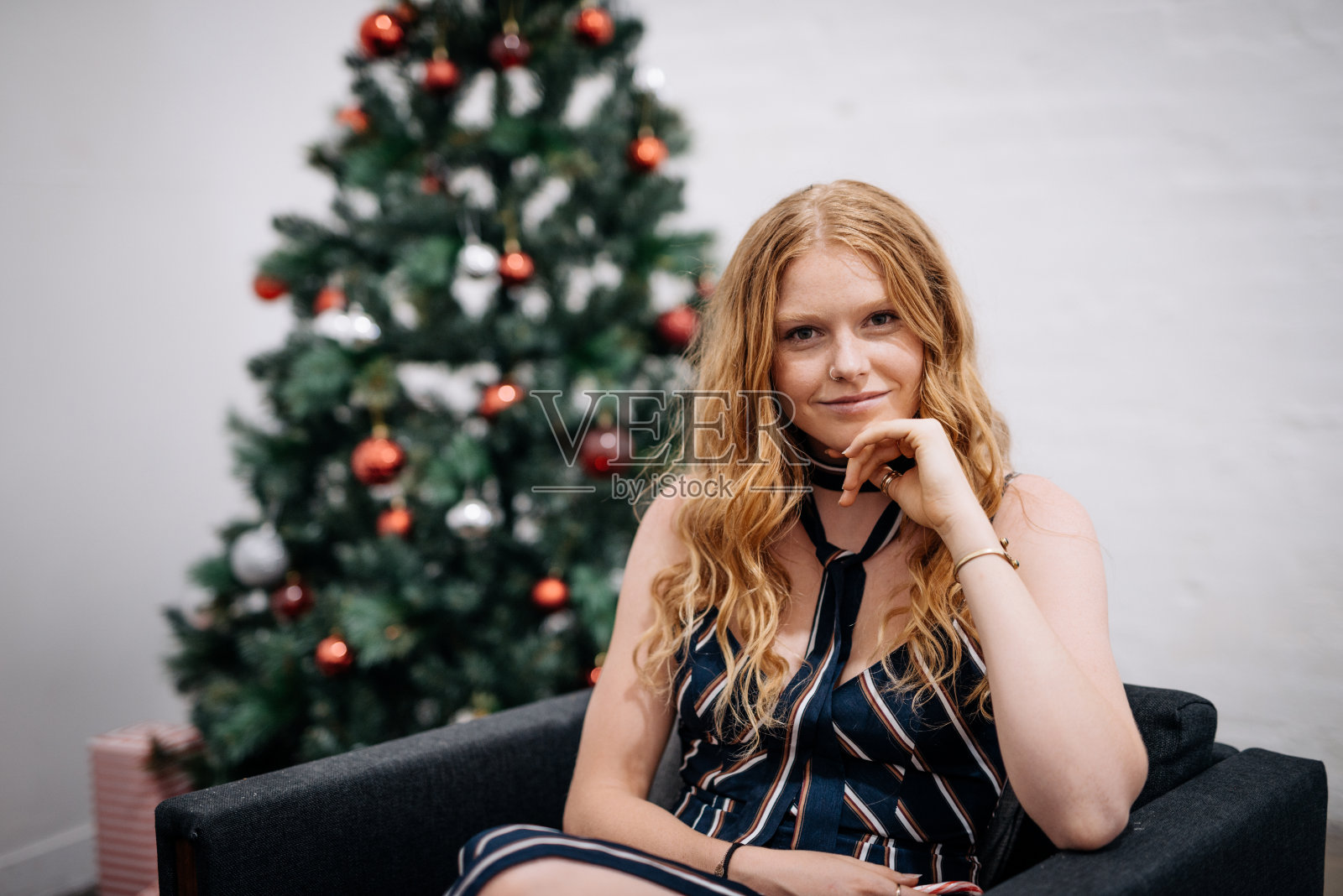 澳大利亚的新年，红发女孩坐在圣诞树旁照片摄影图片