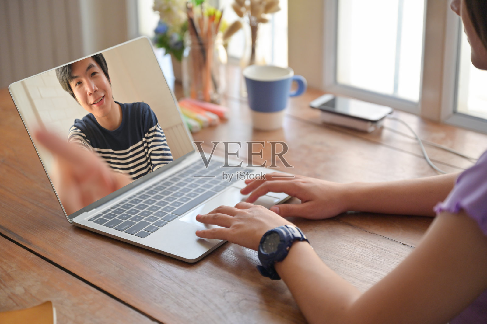 年轻女性用笔记本电脑和男性朋友在线视频聊天。照片摄影图片
