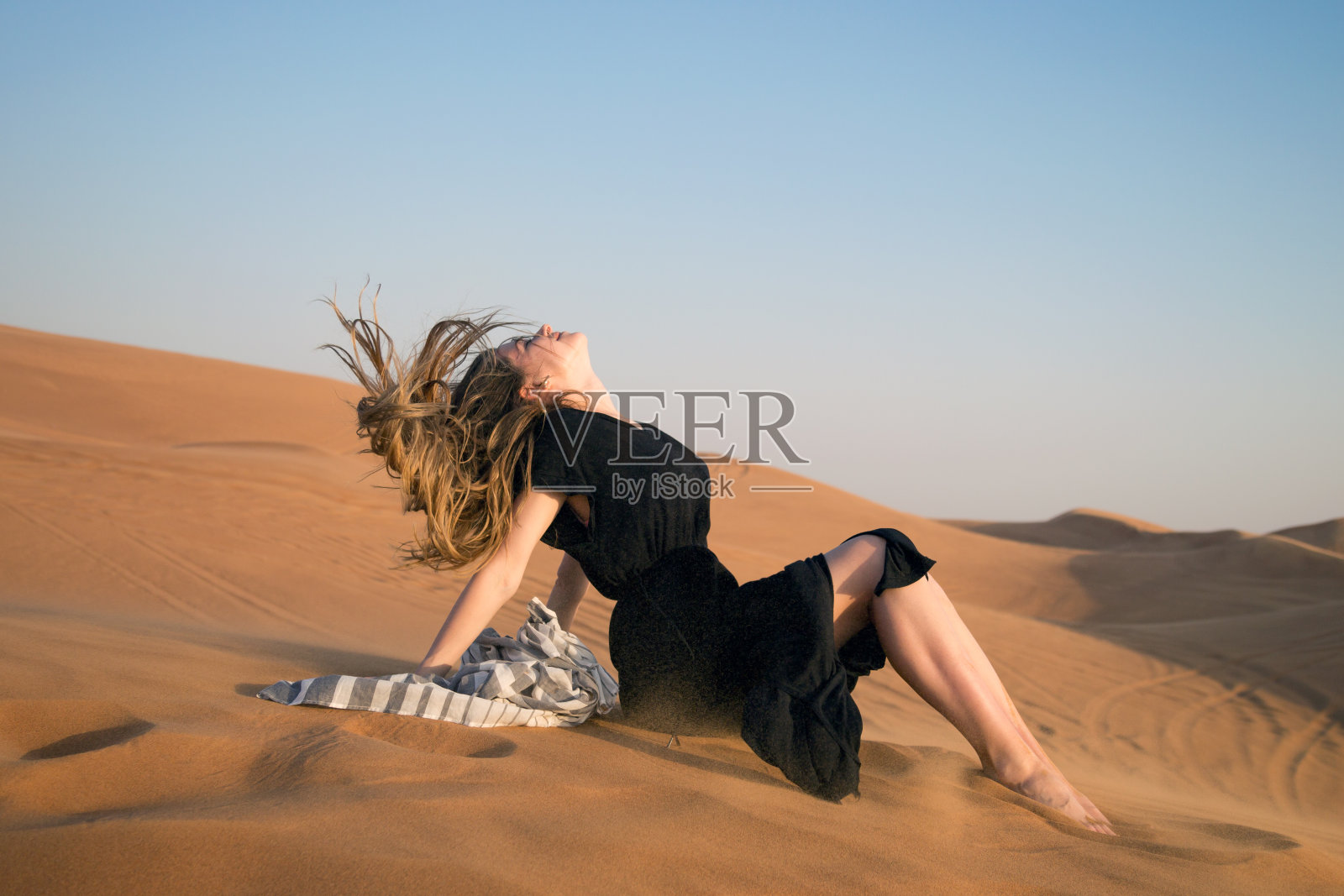 这个女孩在沙漠中因风长出了头发。照片摄影图片