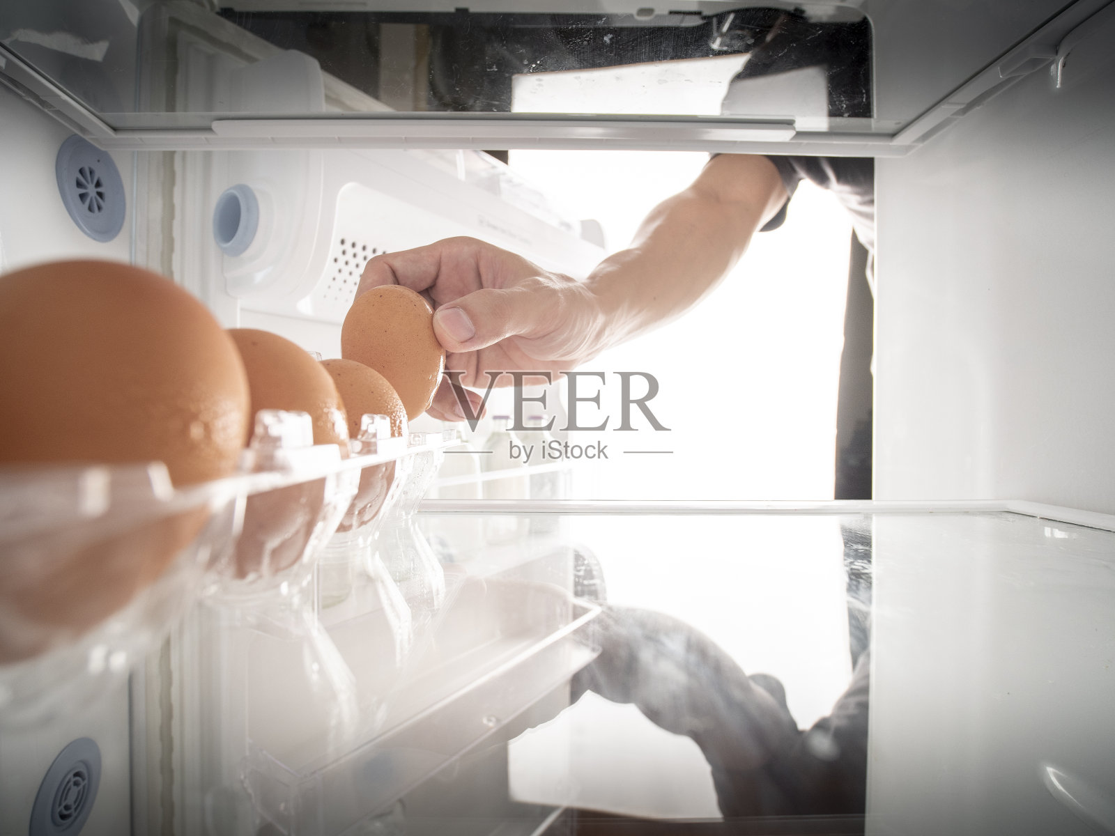 用手从冰箱托盘中挑选鸡蛋，右边有复印的空间。照片摄影图片
