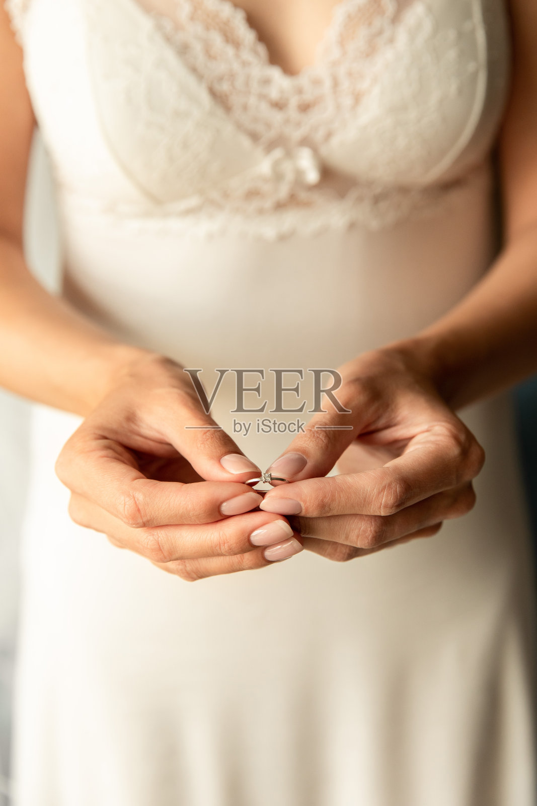 婚礼当天，新娘戴着订婚戒指。婚姻的概念照片摄影图片