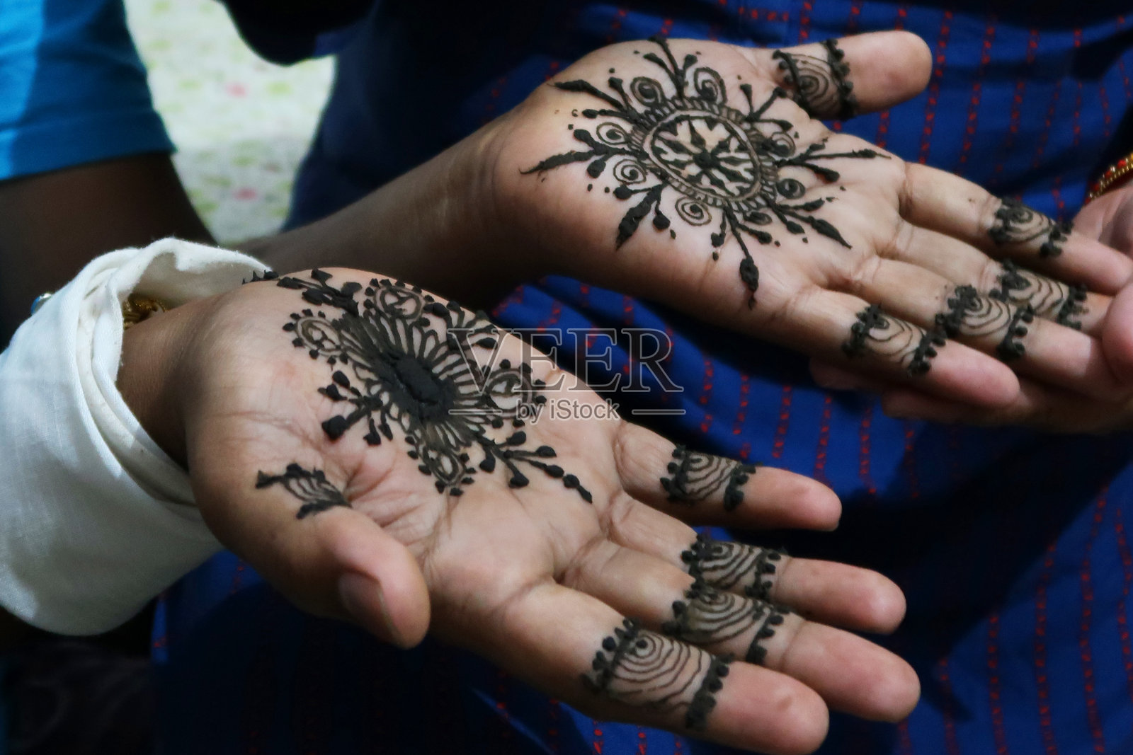 一个不认识的男人用指甲花或曼海蒂粘贴纹身设计展示自己的手，这是印度次大陆的婚礼传统，被称为曼海蒂仪式，为新娘和新郎带来积极的精神，健康，繁荣和好运。照片摄影图片