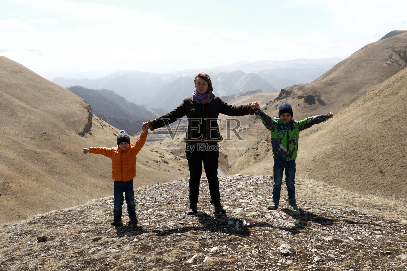 母亲和儿子在高加索山脉的岩石背景照片摄影图片
