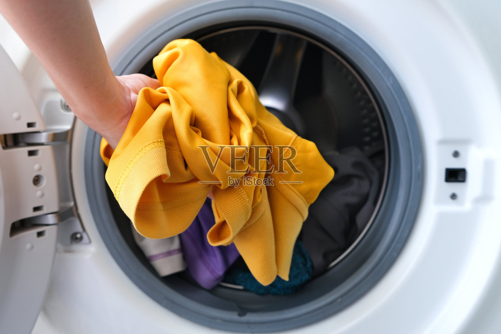 女人的手拿衣服洗衣机。清洁和健康的概念。软焦点照片摄影图片