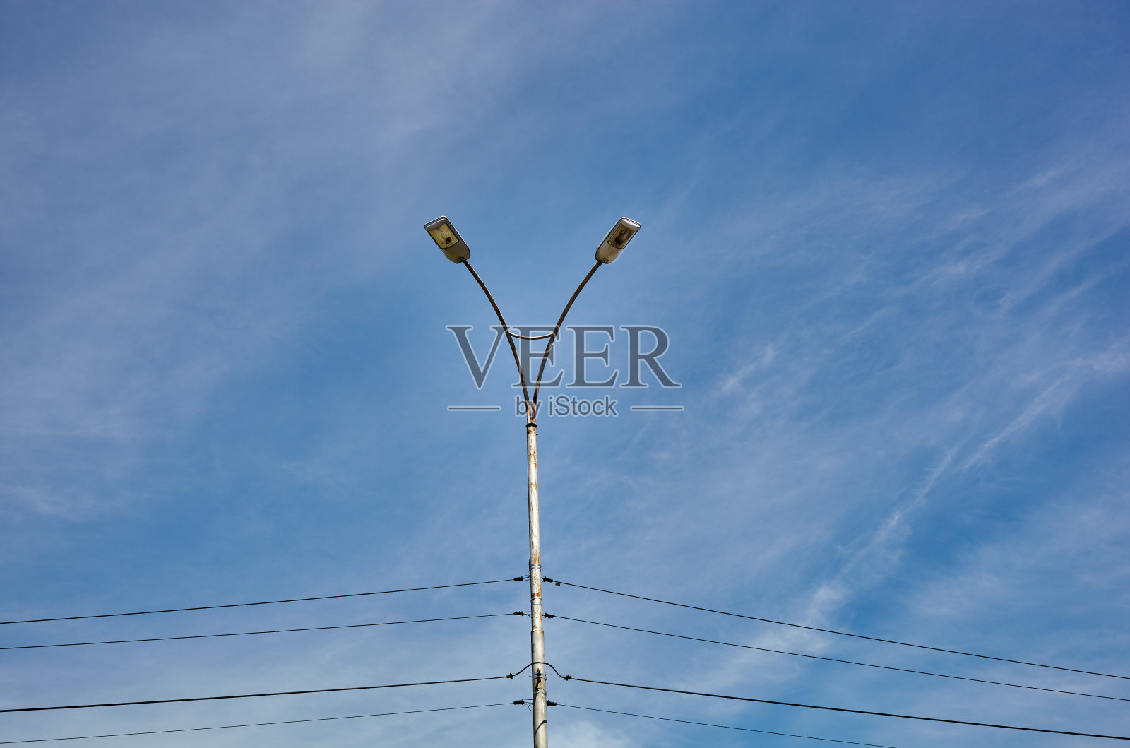 街灯柱上有两盏灯。蓝色天空背景上的路灯照片摄影图片