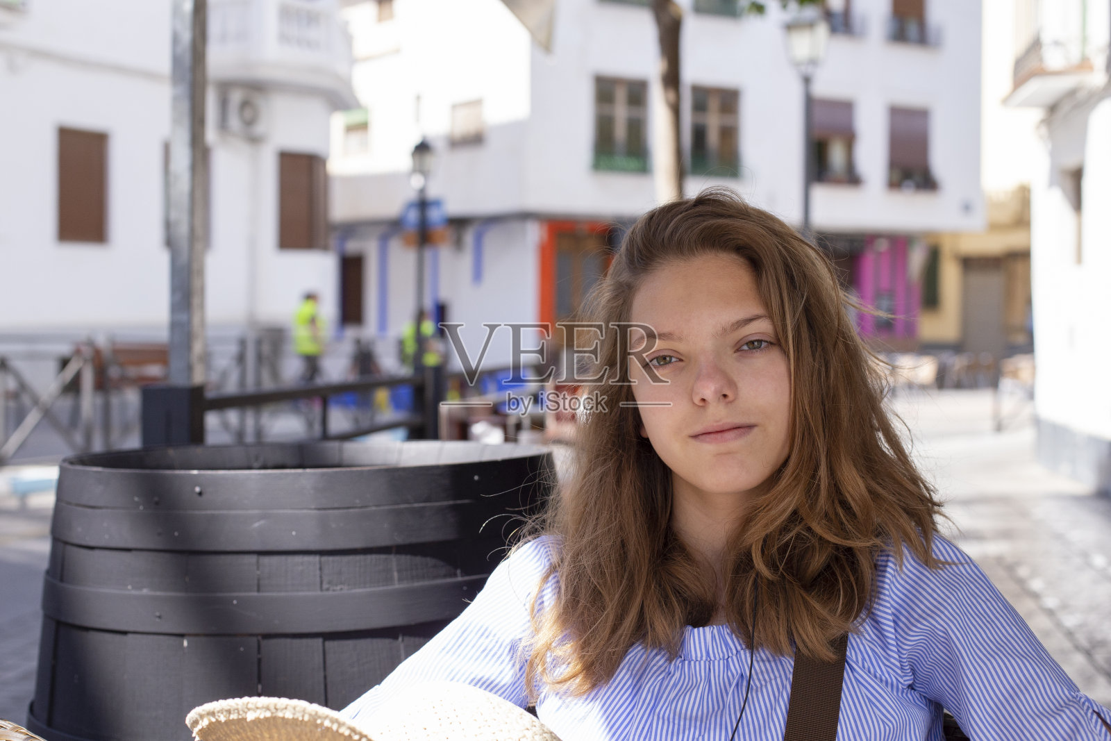 一个可爱的白人长头发的女孩正在一个夏日的街头咖啡馆休息。照片摄影图片