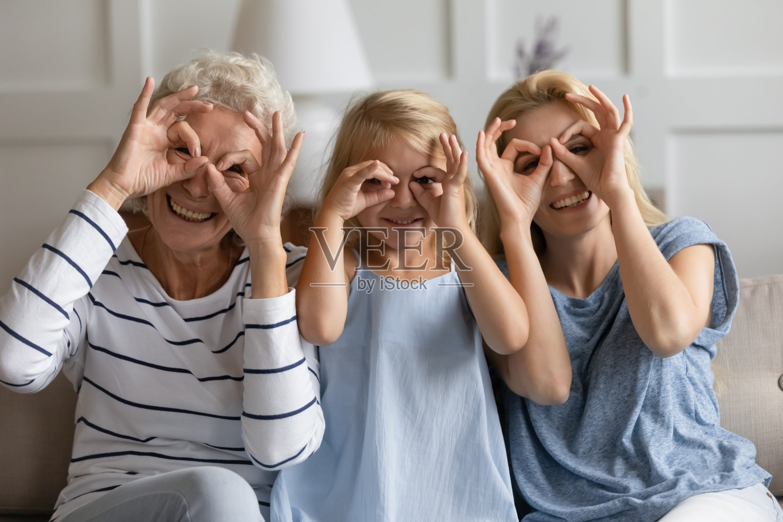 三代妇女用手指做出双筒望远镜一样的眼镜形状照片摄影图片