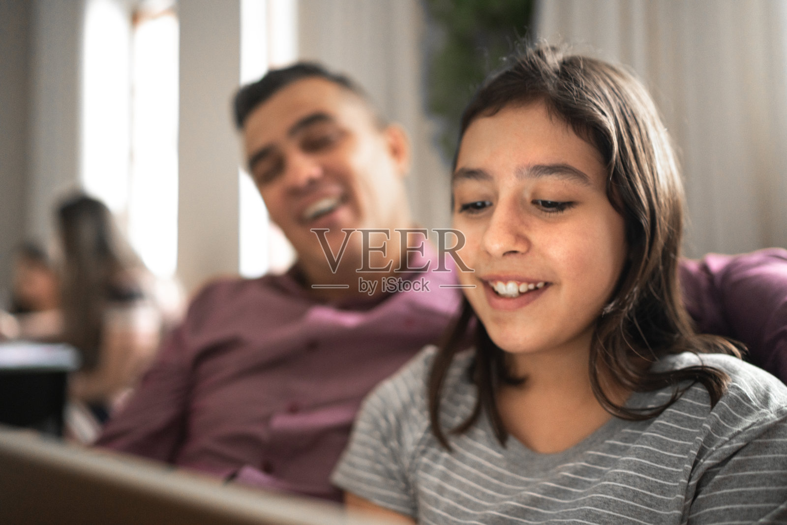 父亲和女儿正在用家里的平板电脑进行视频通话照片摄影图片