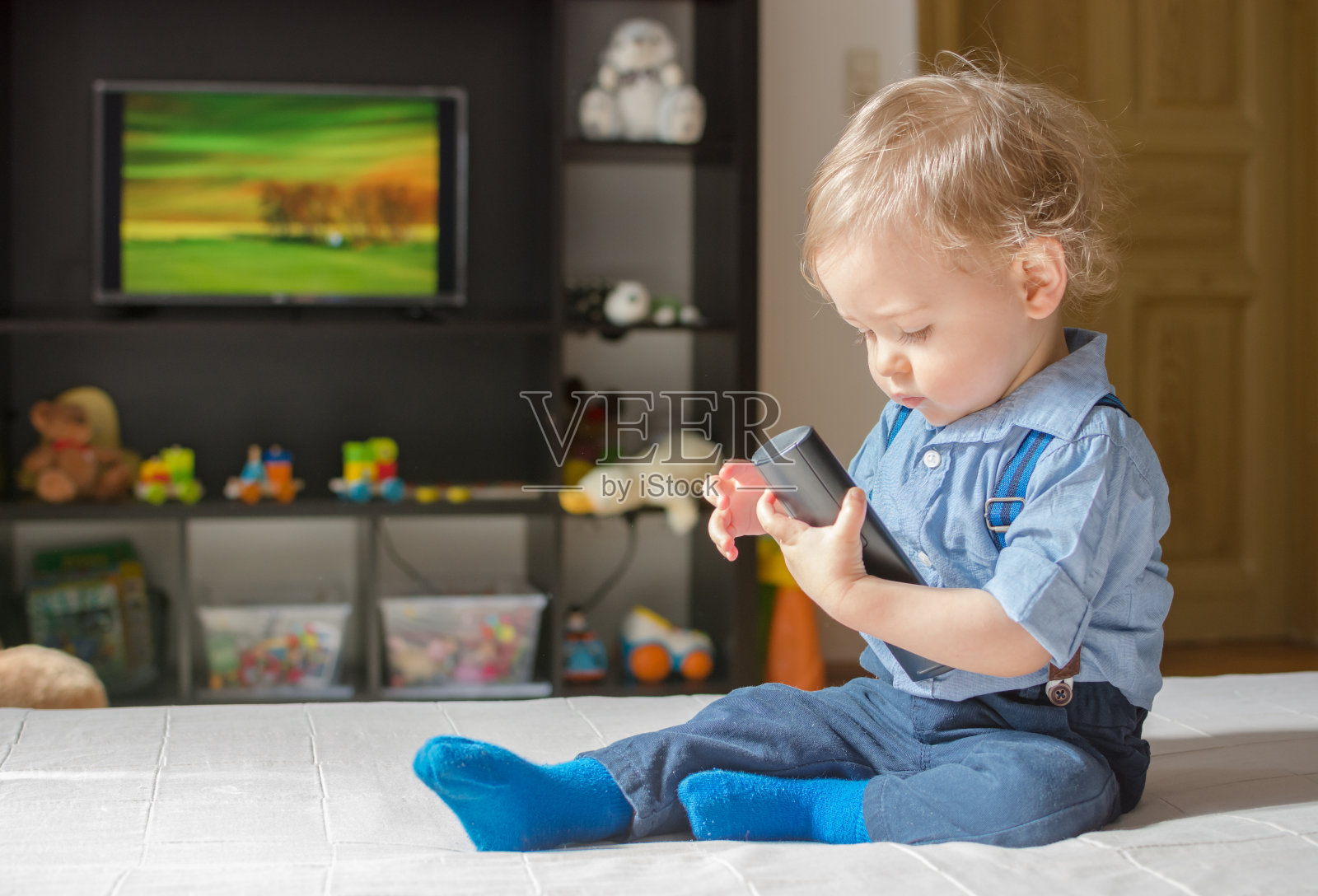 可爱的小男孩在沙发上玩手机游戏-蓝牛仔影像-中国原创广告影像素材