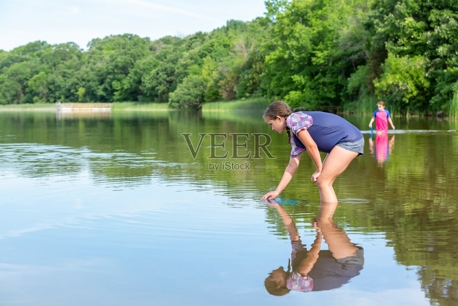 夏天在湖里玩水的女孩照片摄影图片