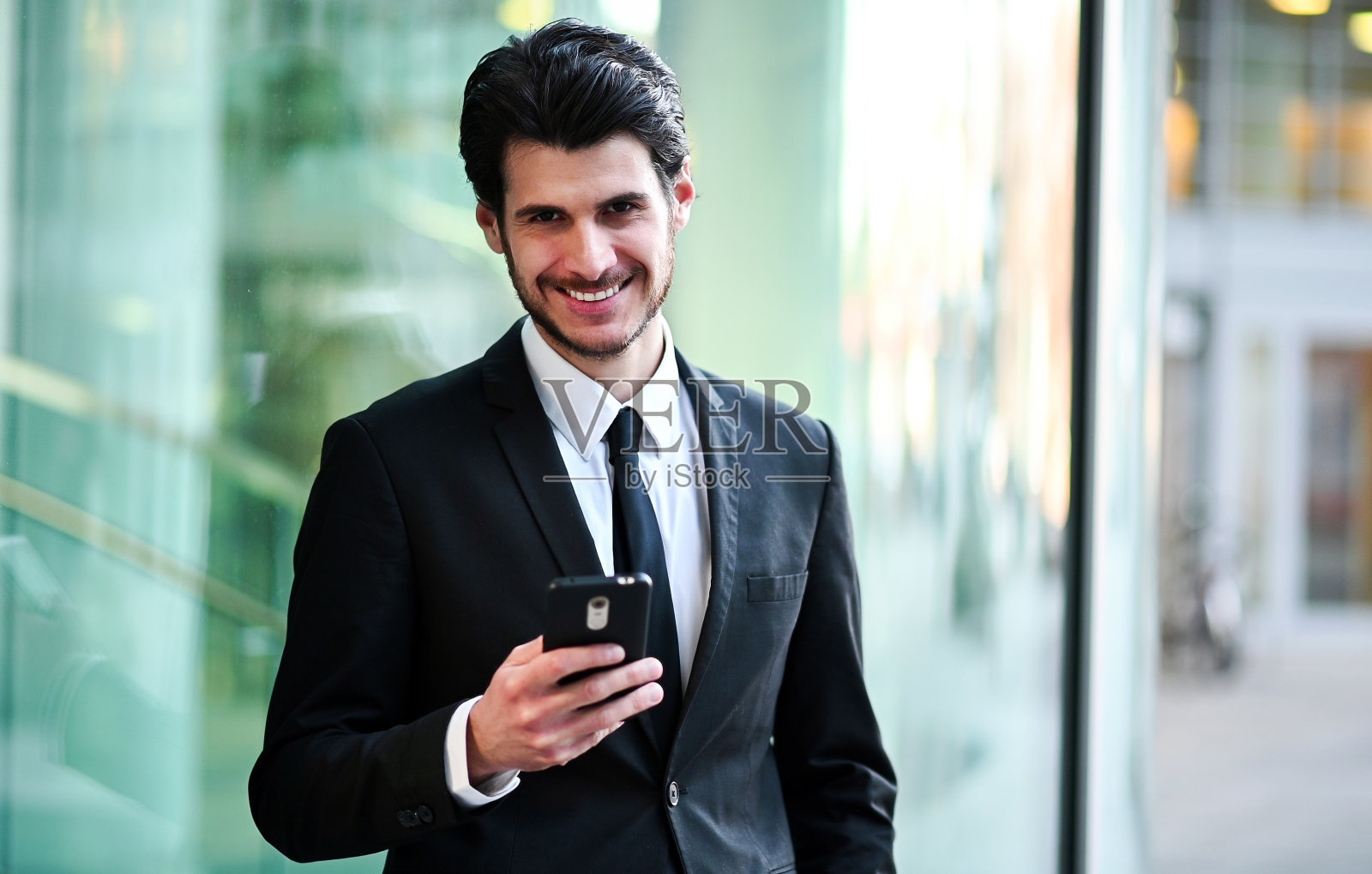 年轻帅气的经理在室外使用智能手机照片摄影图片