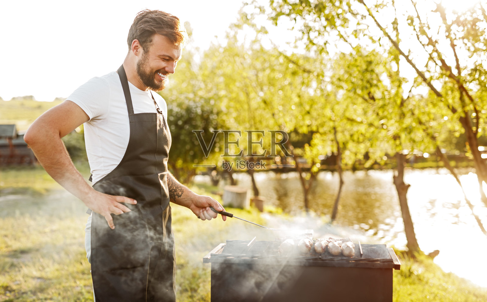 欢快的厨师在烤架上煎肉照片摄影图片