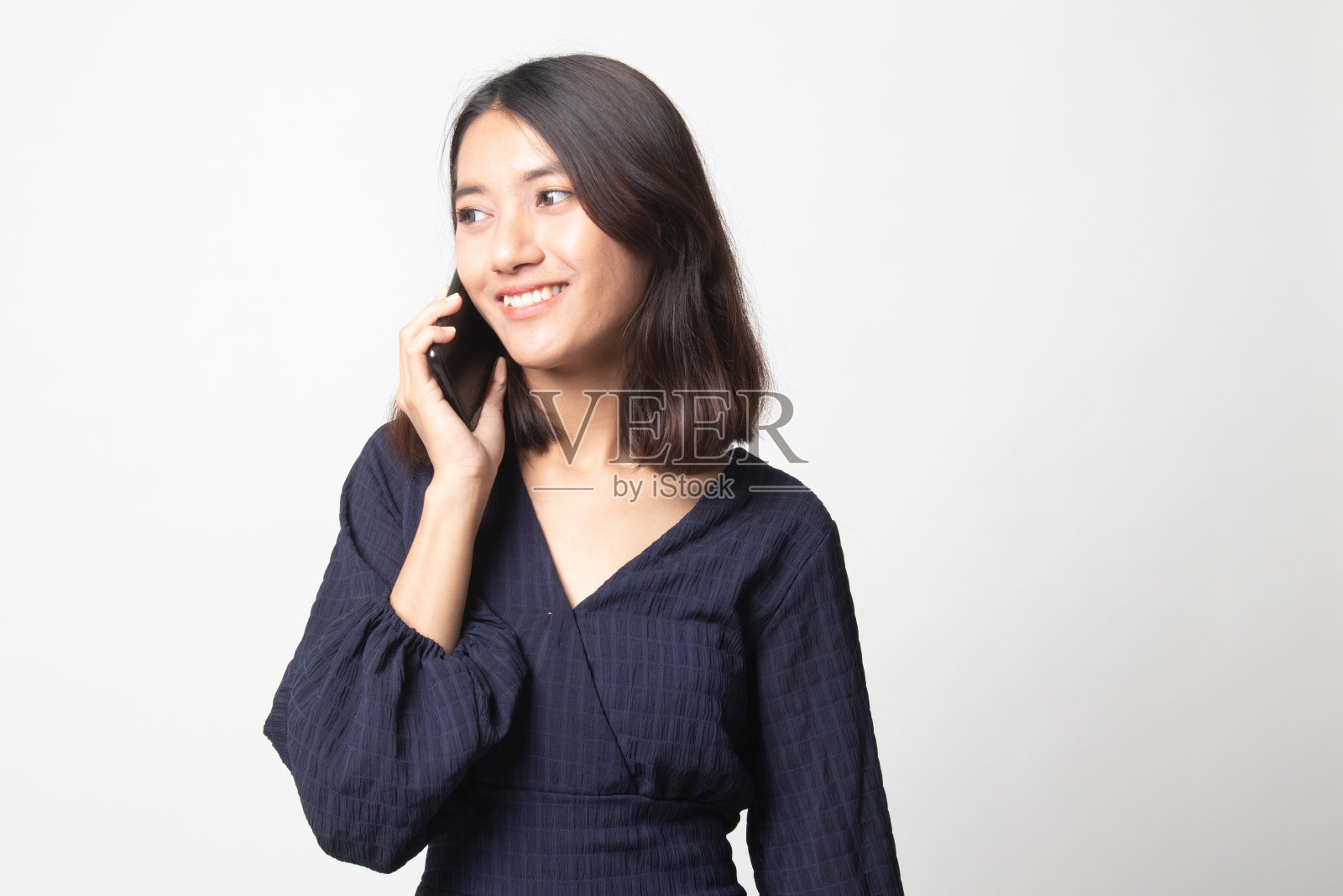 年轻的亚洲女子与手机交谈。照片摄影图片