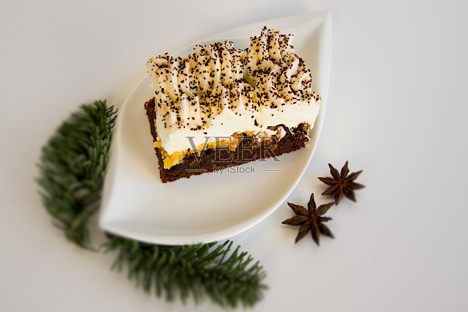 在白色的底座上放一块蛋糕在白色的盘子和圣诞装饰照片摄影图片