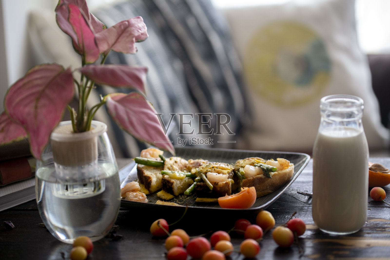 自制早餐:桌上有牛奶、樱桃和烤面包照片摄影图片