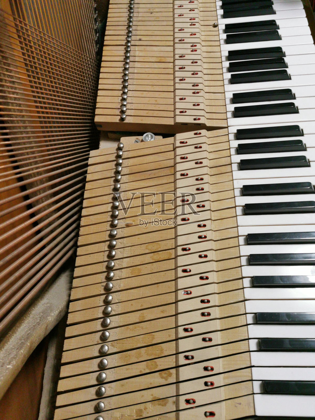 一架小型三角钢琴内的琴弦修理照片摄影图片