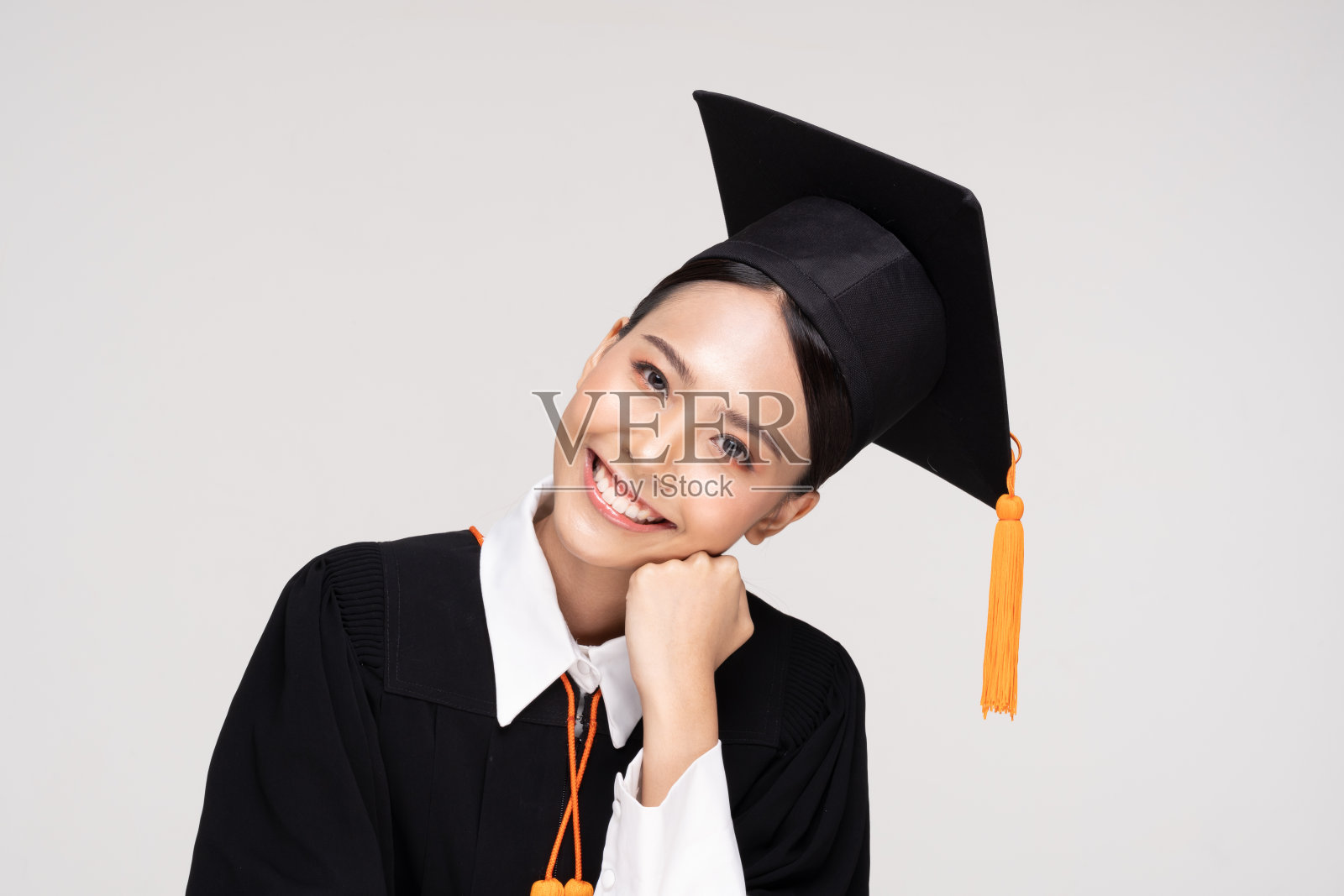 美丽迷人的亚洲女子毕业在帽子和长袍微笑如此骄傲和幸福，孤立在白色的背景，教育成功的理念照片摄影图片