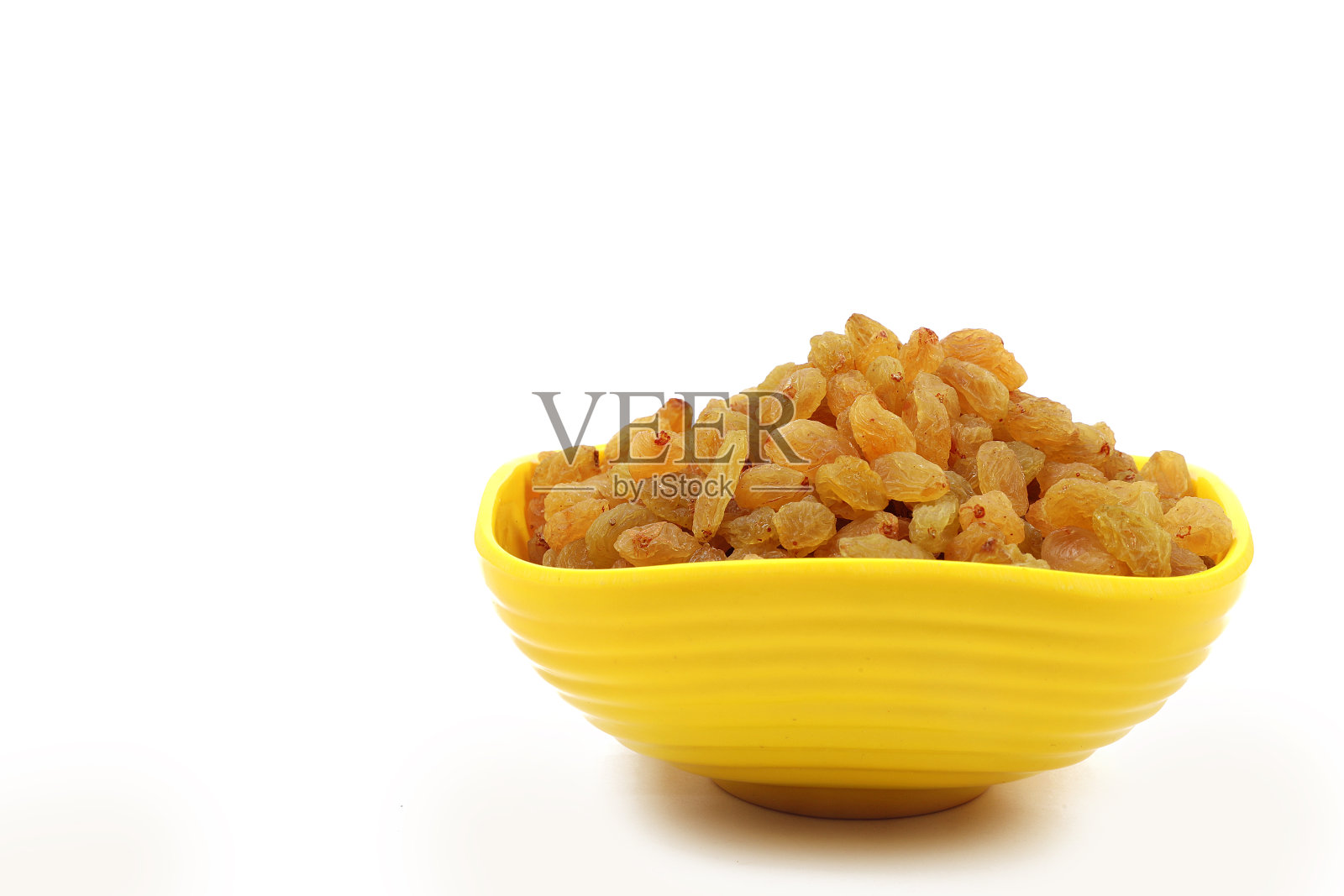 碗与干金黄色葡萄干孤立在白色。干葡萄。照片摄影图片