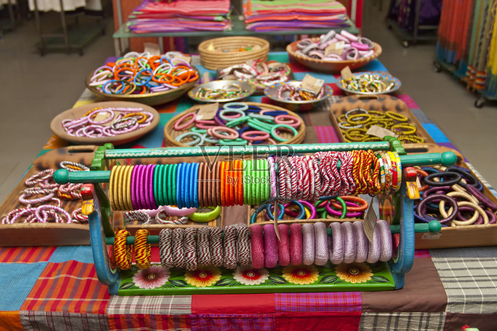 各种颜色的手工手镯陈列在一些小篮子上出售。照片摄影图片
