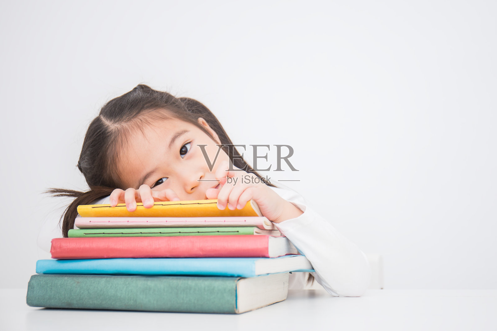 近距离的小可爱的亚洲蹒跚学步的女孩读一本书孤立的白色背景。家庭学校和教育学习理念照片摄影图片