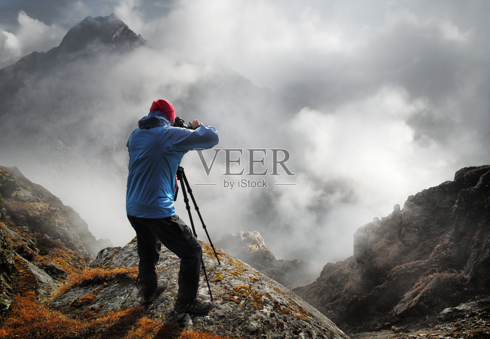 摄影师旅行者与相机拍照的山站在山顶，享受照片照片摄影图片