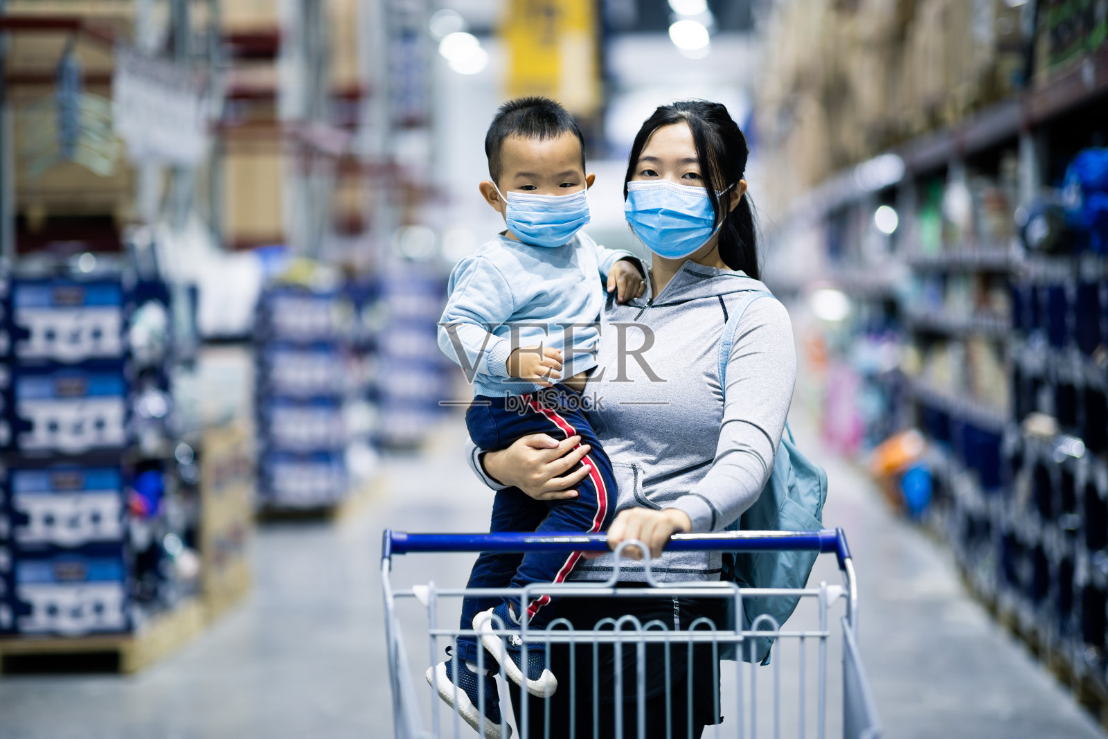 亚洲妇女抱着婴儿戴着脸在超市购物照片摄影图片