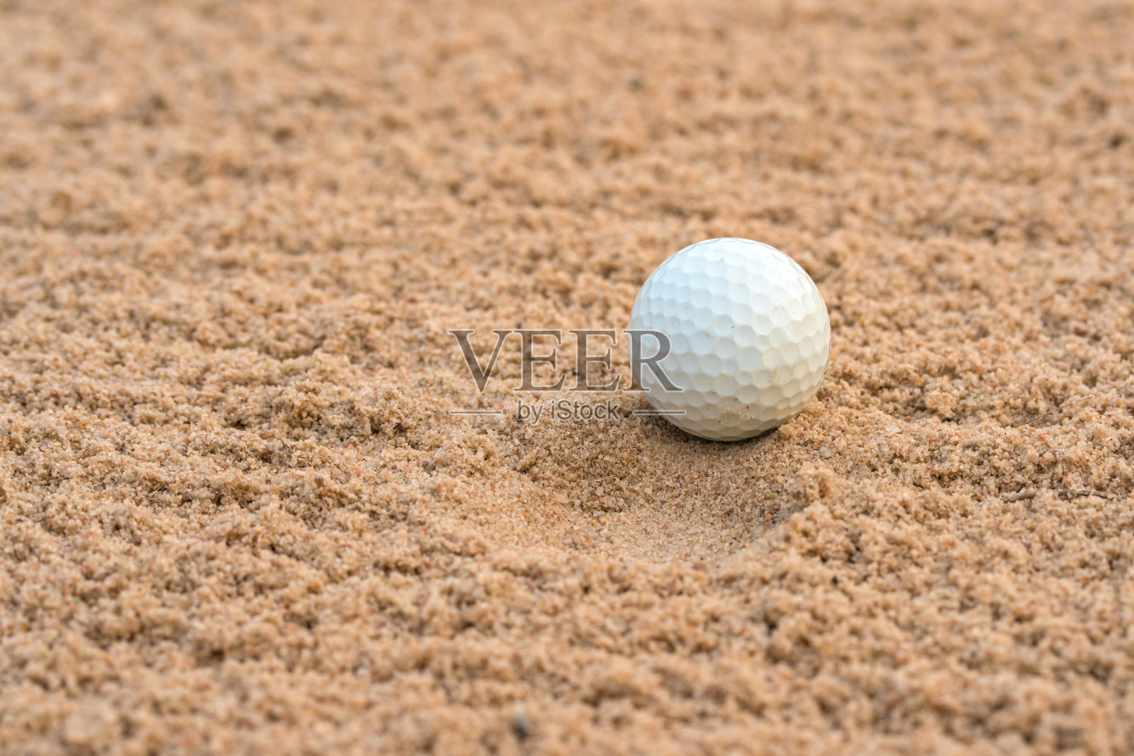 高尔夫球手在高尔夫球场的沙坑上打高尔夫球照片摄影图片