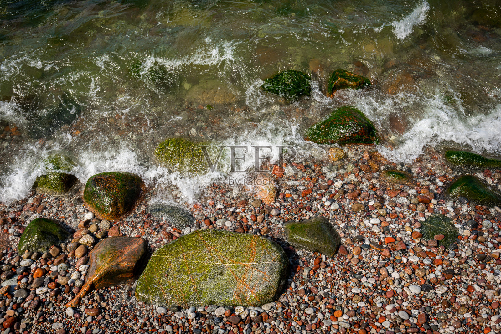 岩石海滩上的石头、鹅卵石和淡水的特写镜头。照片摄影图片