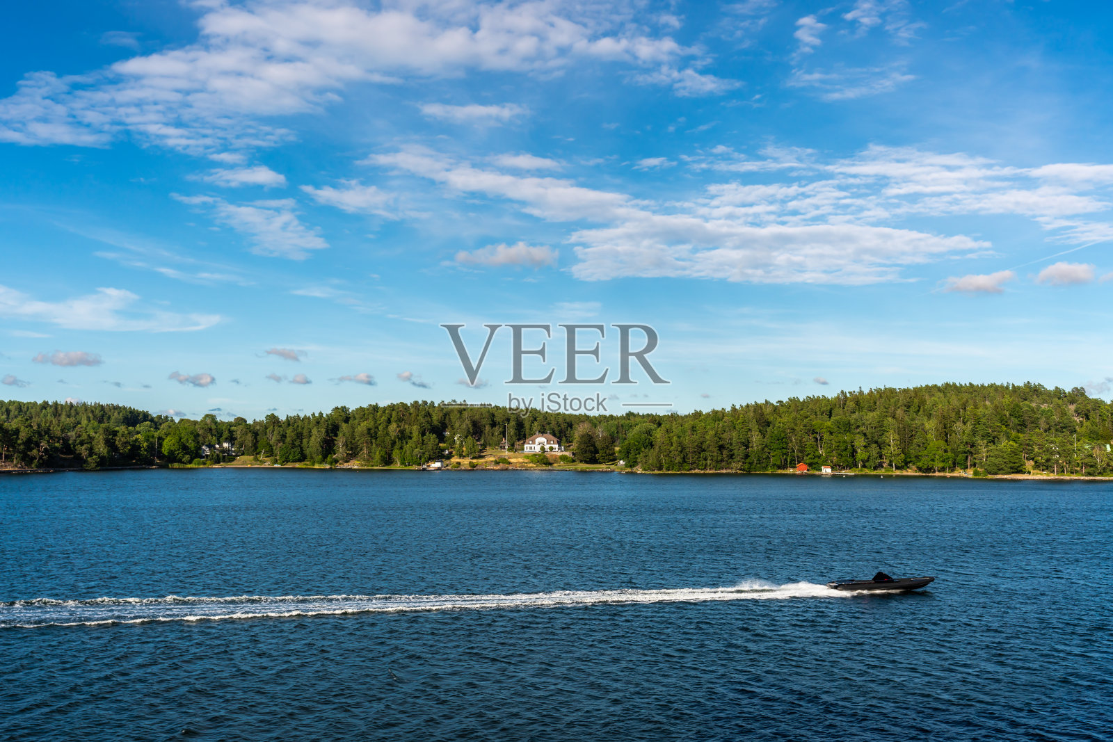 夏天的海边风景，一个快速的快艇与蓝色的天空和陆地地平线。照片摄影图片