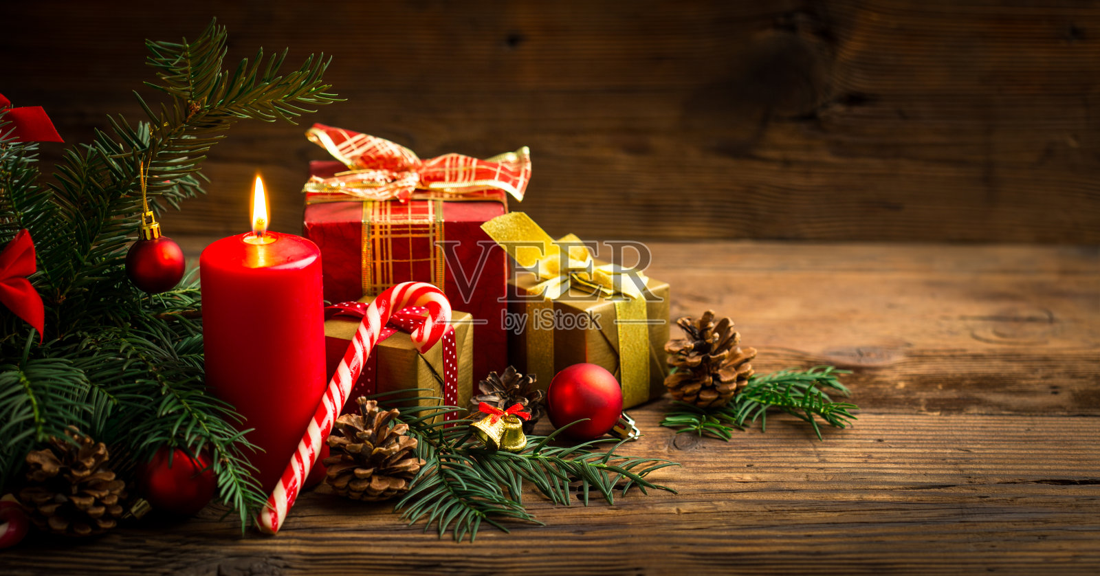 圣诞装饰用蜡烛和礼物在木制的背景照片摄影图片