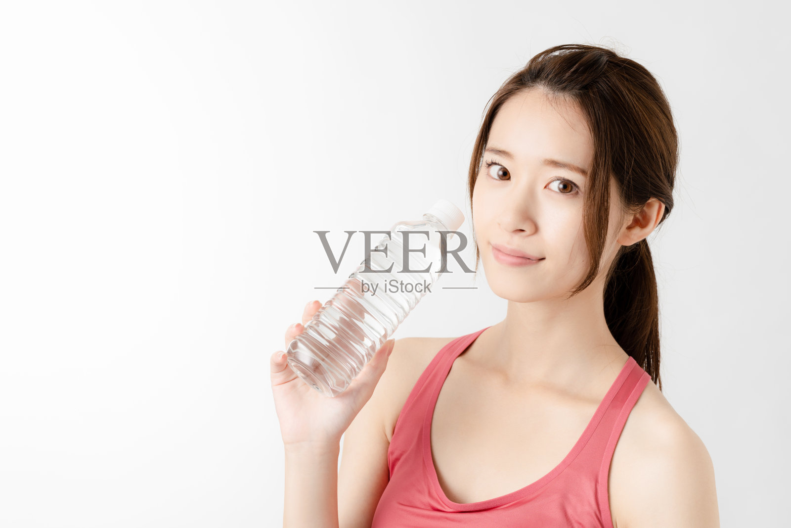 一个年轻女子拿着一瓶水。照片摄影图片