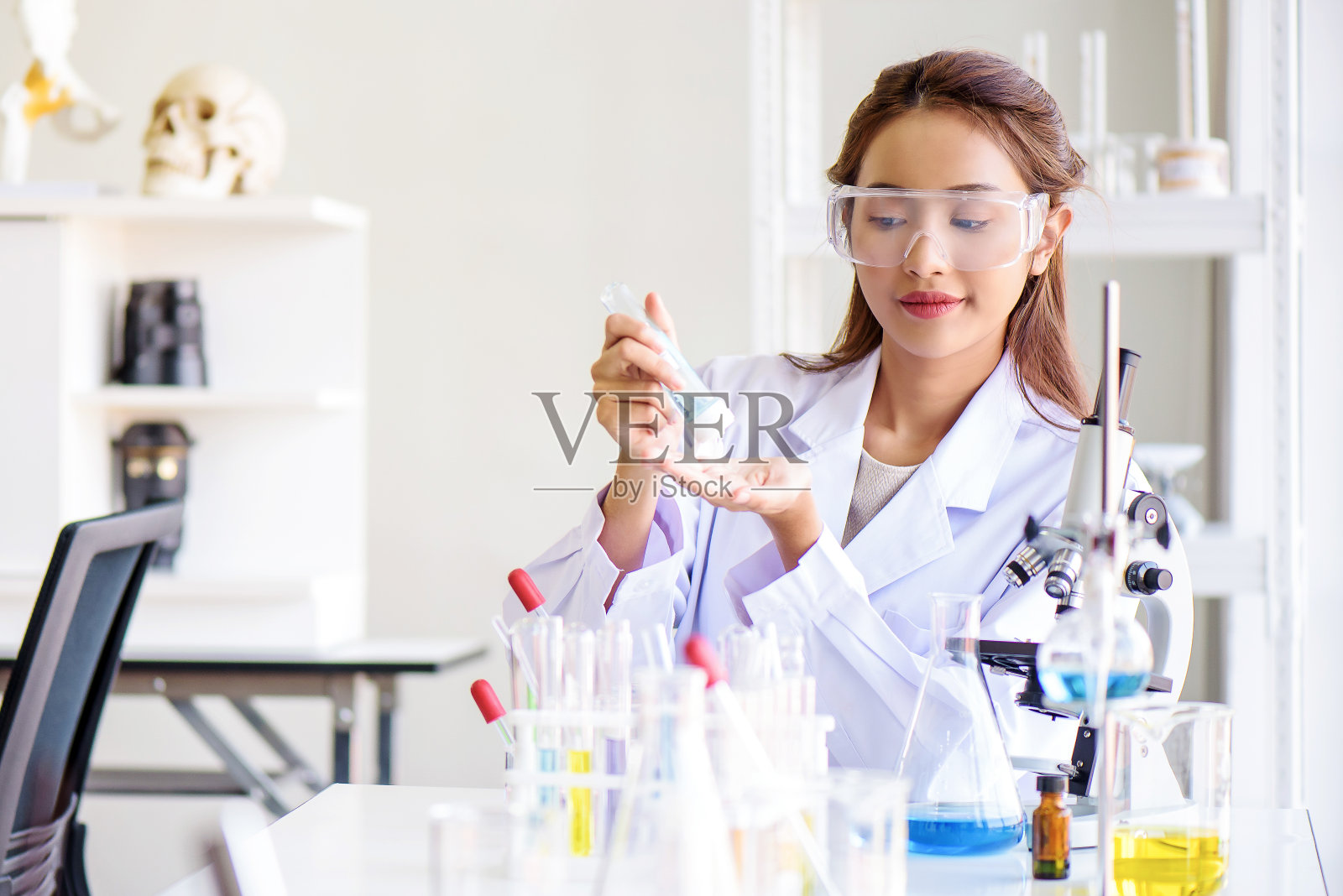 迷人的幸福科学家女实验室技术员助理显示酒精洗手凝胶在实验室。医学、制药和科研开发理念。照片摄影图片