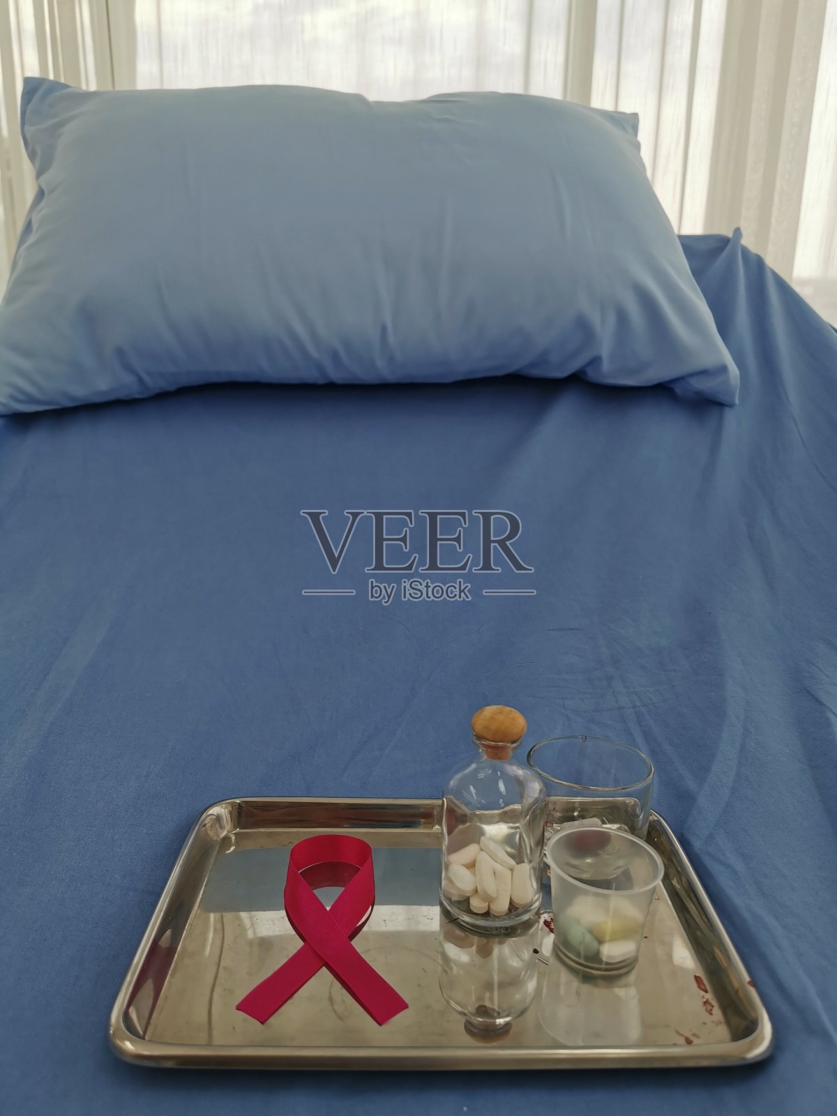 医院病床上的医疗托盘上的粉色蝴蝶结标志，象征着乳腺癌意识周照片摄影图片