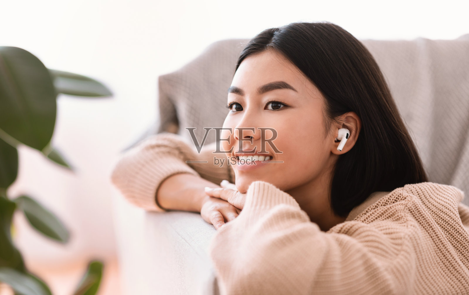 亚洲女性戴着无线耳机听音乐照片摄影图片