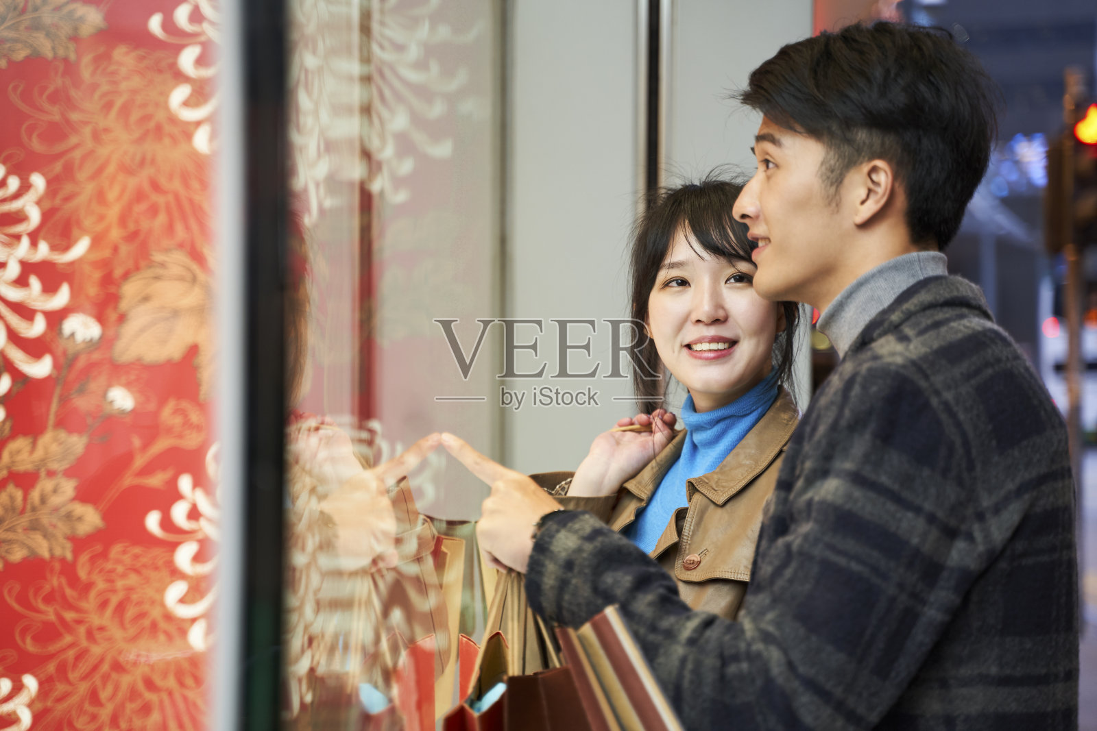 幸福的年轻亚洲夫妇看橱窗照片摄影图片