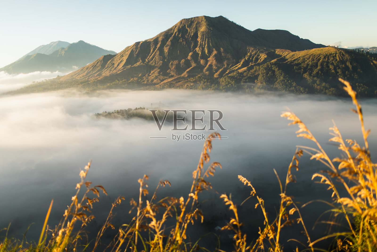 从平干村看巴图尔火山的日出。美丽的日出和低低的云彩。全景。照片摄影图片