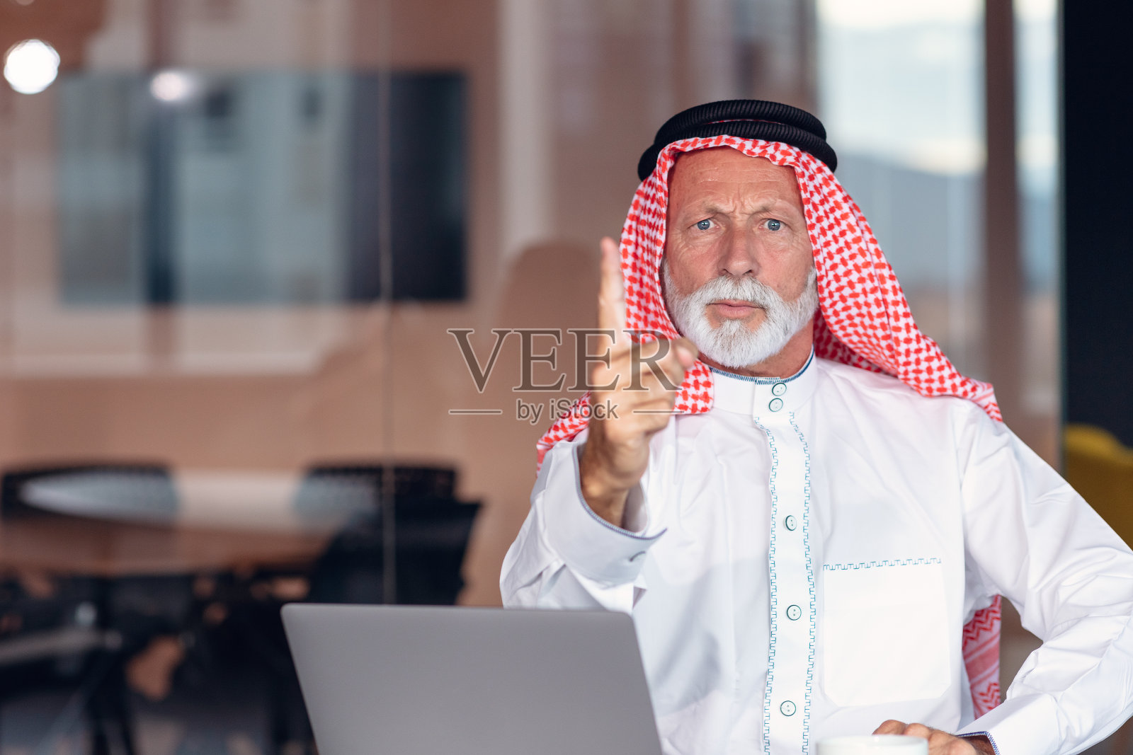 一名阿拉伯商人用手指指着镜头以示警告。照片摄影图片
