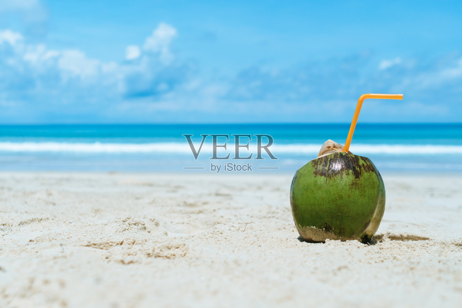 新鲜的椰子在沙滩上在夏天的海滩蓝色的天空背景。照片摄影图片
