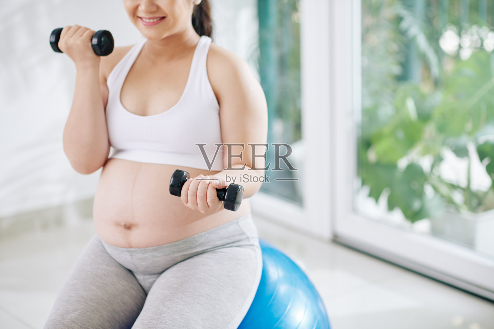 孕妇用哑铃锻炼身体照片摄影图片